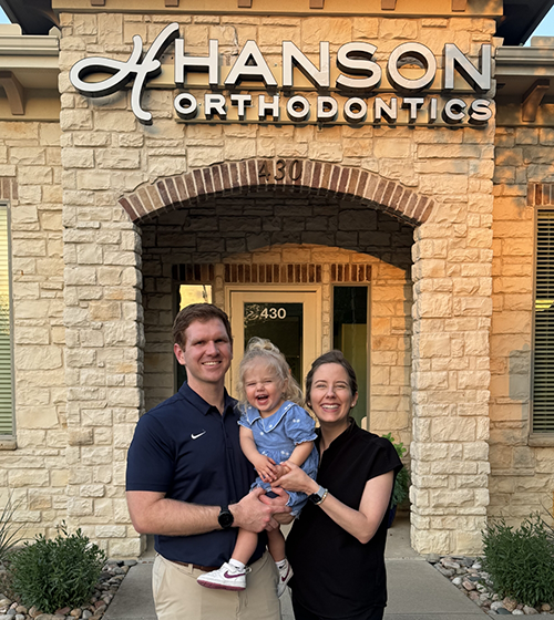 Doctor Hanson smiling with her husband and their baby