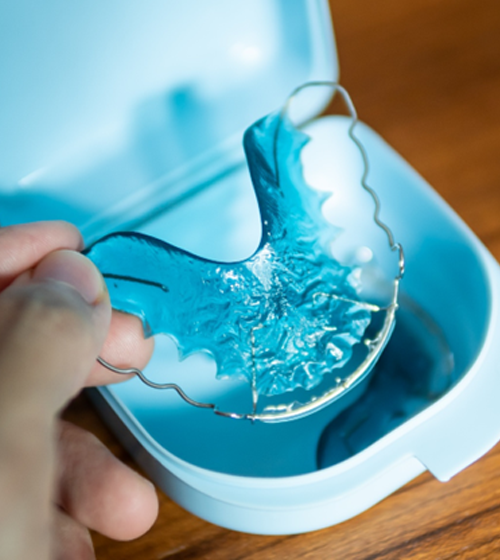 Person lifting a Hawley retainer from its case