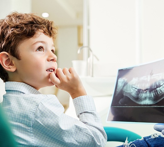 Boy visiting orthodontist and looking at X-ray