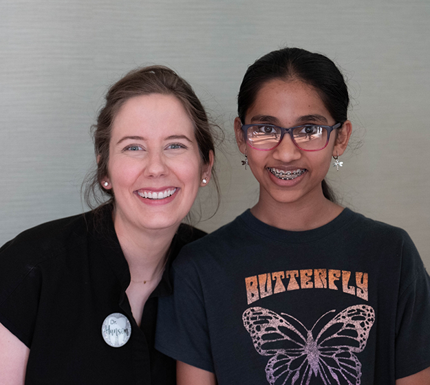Teenage girl in dental chair smiling with traditional braces in Allen
