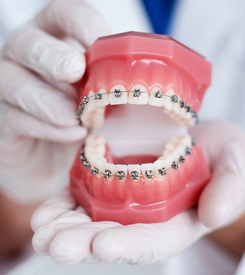 Young woman in orthodontic treatment chair smiling up at the camera