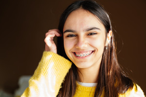 Teenage girl with yellow sweater and braces